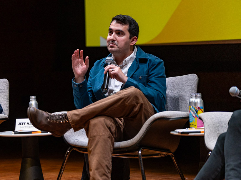 Jeff MacDonald sitting on a chair on stage